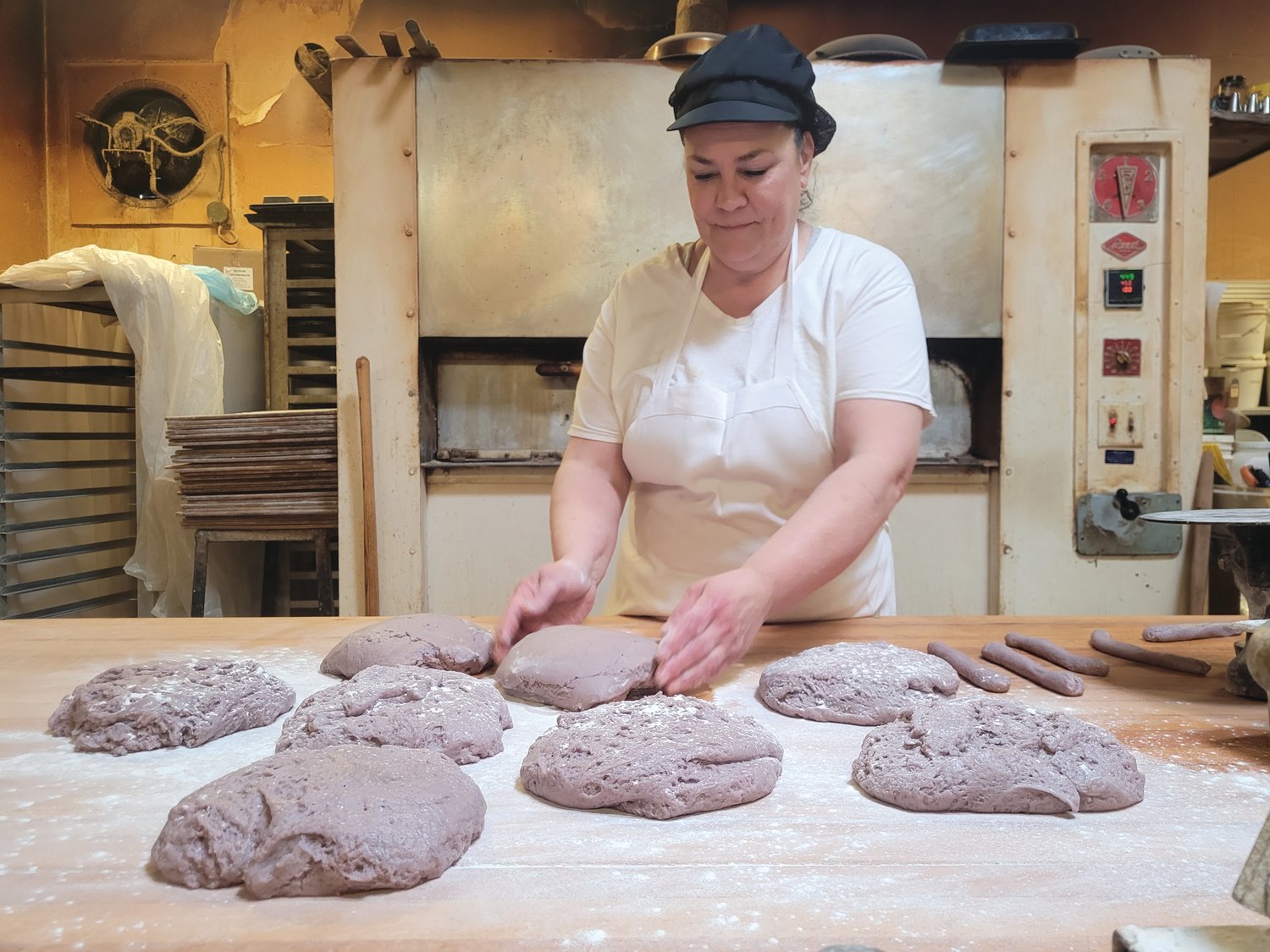 WINE, DON’T WHINE: Elena Pennacchini stood in the back of her family bakery, Solitro’s, rolling purple piles of dough into small circular twisted wine biscuits.